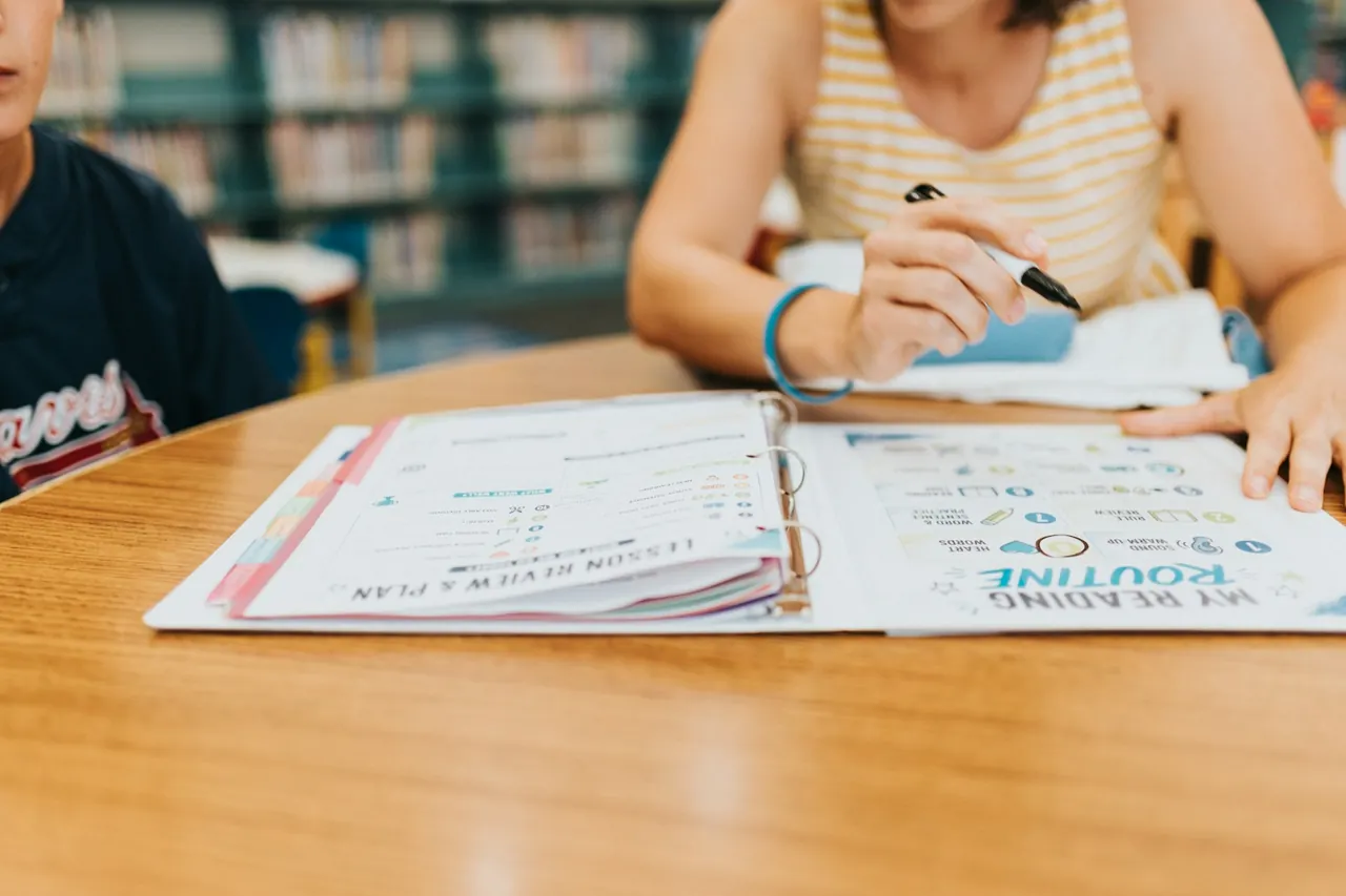 Student writing in an open binder during a study session