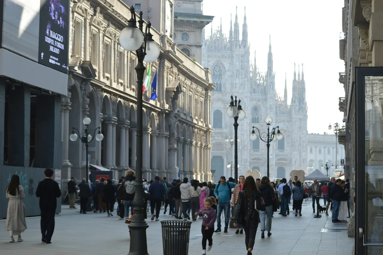 People walking along a street between historic buildings in Milan